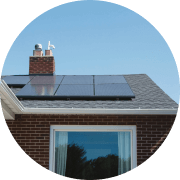 Solar panels on top of a roof looking up from the ground